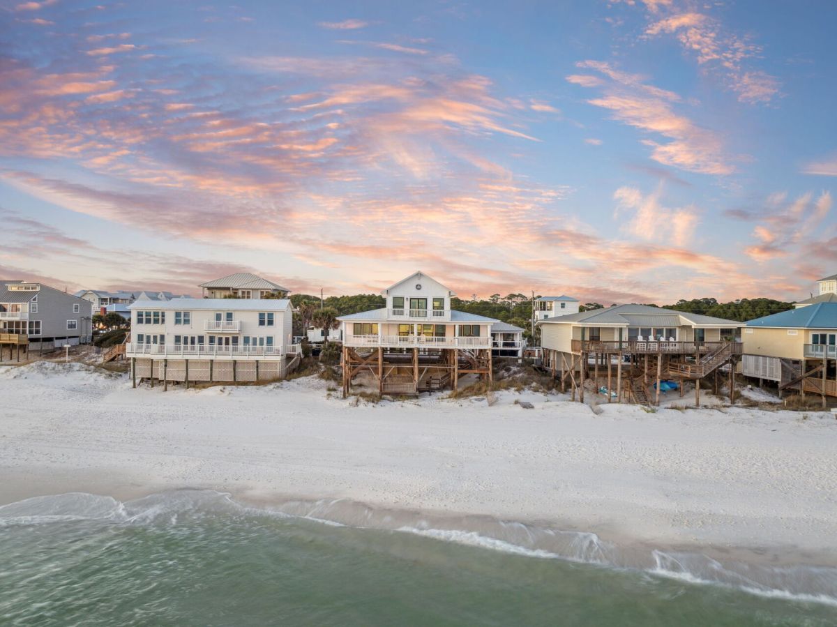 view of a beachfront home at sunset
